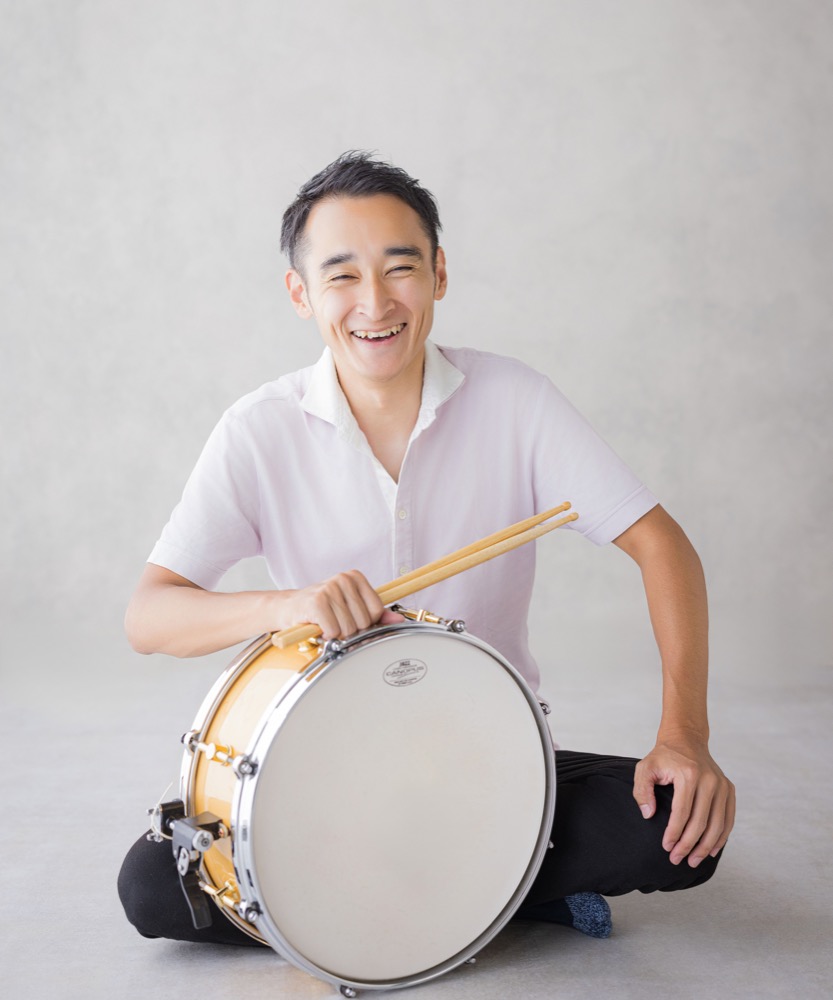 スネアドラムを抱えて笑う講師の吉川直樹